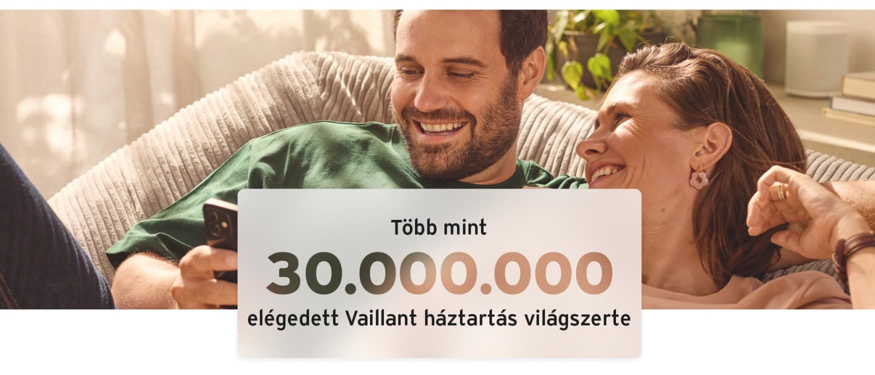 Pár kényelmesen ül bent, mosolyogva nézi a telefonját.